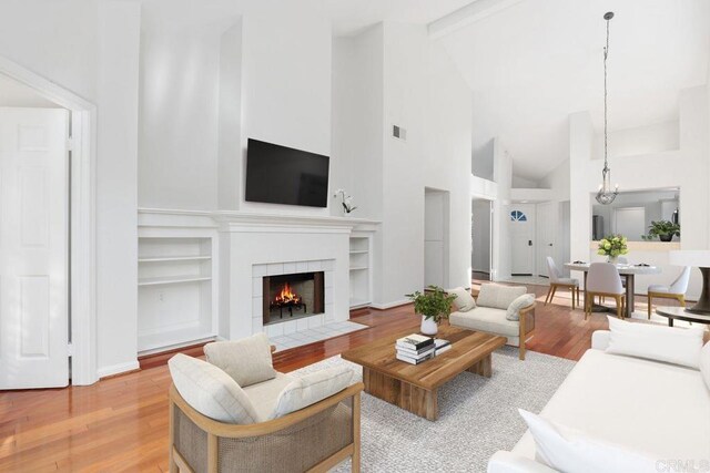 814 Okra Ct, Carlsbad, CA 92011 - living room with high vaulted ceiling, a fireplace, light wood finished floors, built in features, and beamed ceiling
