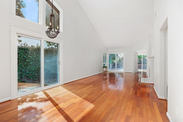 814 Okra Ct, Carlsbad, CA 92011 - unfurnished living room with high vaulted ceiling, a chandelier, and wood-type flooring