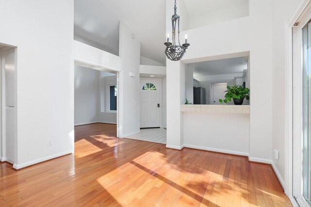 814 Okra Ct, Carlsbad, CA 92011 - unfurnished dining area with wood-type flooring, a chandelier, and high vaulted ceiling