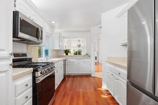 814 Okra Ct, Carlsbad, CA 92011 - kitchen with appliances with stainless steel finishes, tile counters, white cabinets, backsplash, and recessed lighting