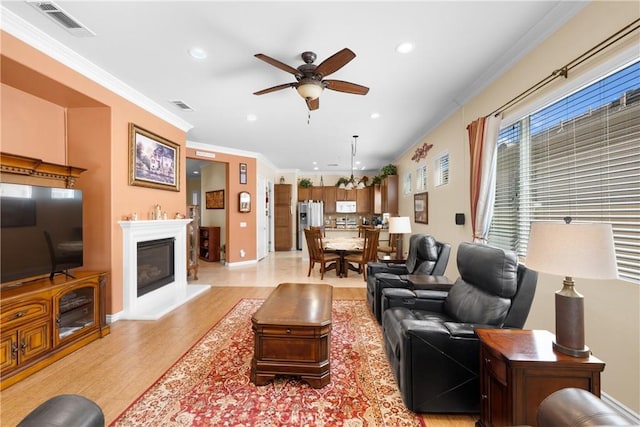 5551 Corte Fiesta, Hemet, CA 92545 - living room with recessed lighting, light wood-style flooring, ceiling fan, crown molding, and a glass covered fireplace