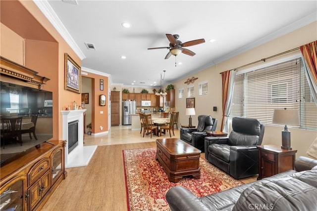 5551 Corte Fiesta, Hemet, CA 92545 - living area featuring crown molding, light wood-style floors, ceiling fan, recessed lighting, and a glass covered fireplace