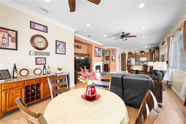 5551 Corte Fiesta, Hemet, CA 92545 - dining room featuring a ceiling fan, recessed lighting, light wood-type flooring, a fireplace, and crown molding