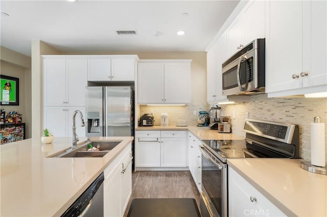 2677 E Tyler St, Long Beach, CA 90810 - kitchen with visible vents, light countertops, white cabinets, a sink, and stainless steel appliances