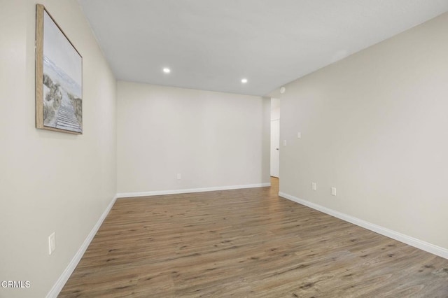 unfurnished room featuring recessed lighting, baseboards, and wood finished floors