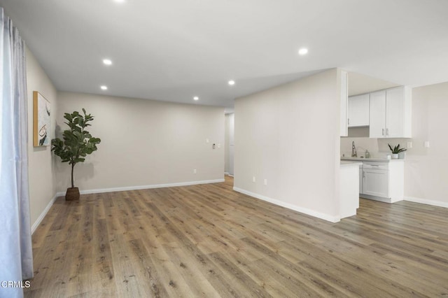 unfurnished living room featuring light wood-type flooring, recessed lighting, and baseboards