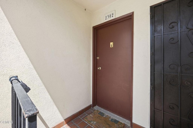 doorway to property featuring stucco siding