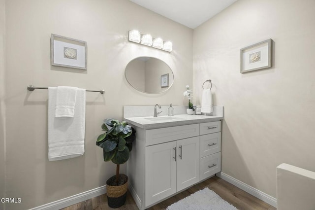 bathroom featuring baseboards, vanity, and wood finished floors