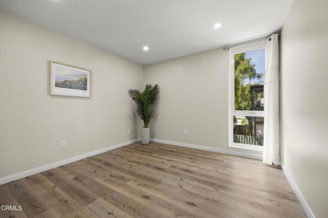 empty room with recessed lighting, baseboards, and wood finished floors