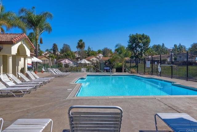 community pool featuring fence and a patio area