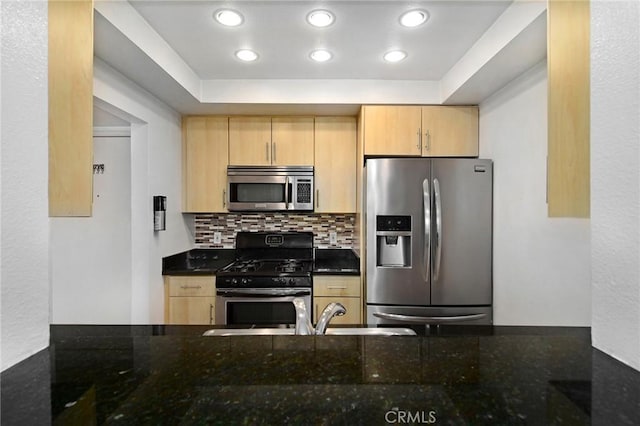 kitchen featuring decorative backsplash, appliances with stainless steel finishes, a sink, a raised ceiling, and light brown cabinets