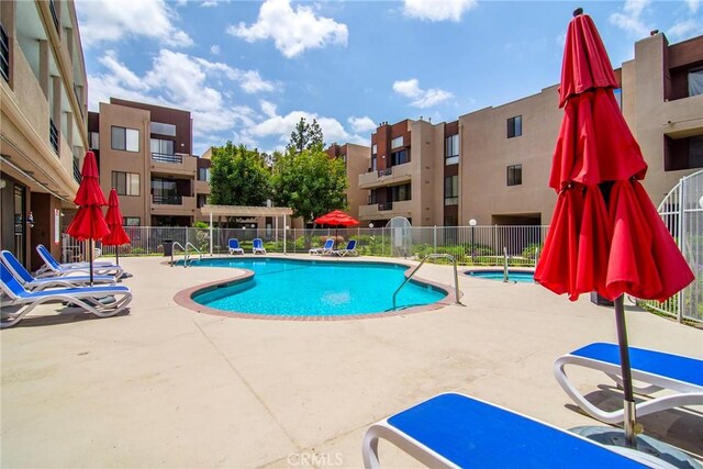 pool with a patio and fence