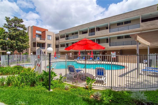 community pool with fence and a patio area