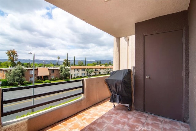 balcony with a residential view, a mountain view, and a grill