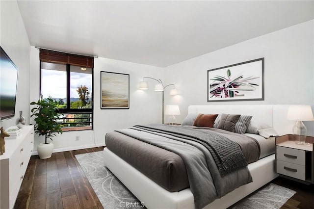 bedroom featuring dark wood-type flooring and baseboards