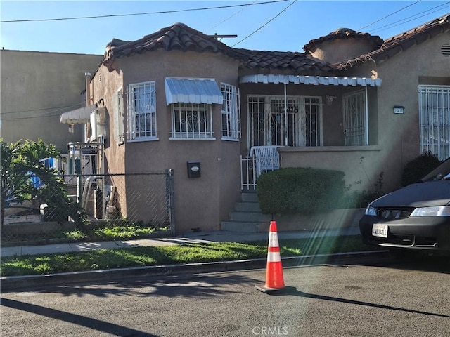 159 E 105th St, Los Angeles, CA 90003 - view of front of house with stucco siding and a tile roof