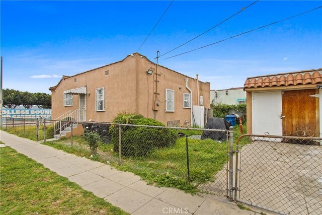 159 E 105th St, Los Angeles, CA 90003 - view of side of property with stucco siding and a gate