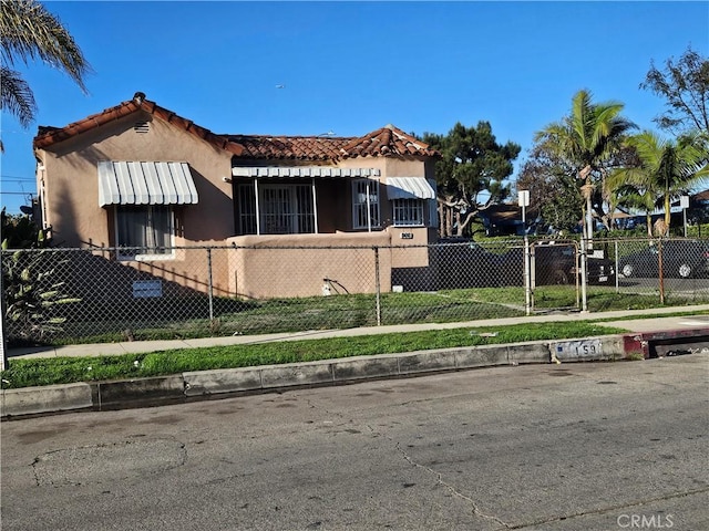 159 E 105th St, Los Angeles, CA 90003 - view of side of home with a fenced front yard, a tile roof, and stucco siding