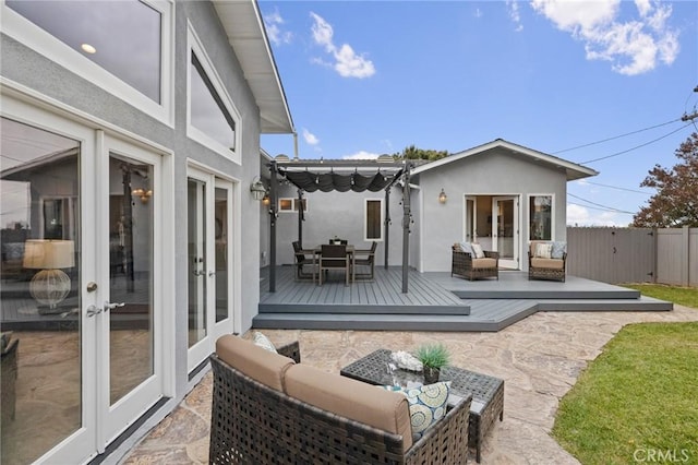 rear view of house featuring french doors, an outdoor living space, a wooden deck, stucco siding, and fence