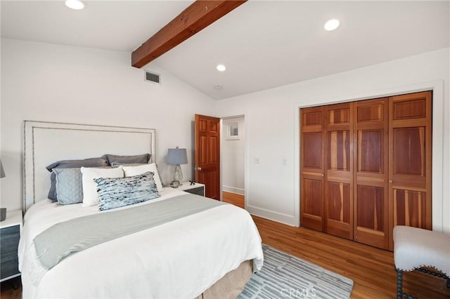 bedroom with wood finished floors, recessed lighting, a closet, and baseboards