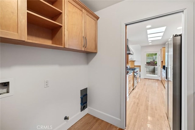 washroom with cabinet space, light wood-style flooring, baseboards, washer hookup, and recessed lighting