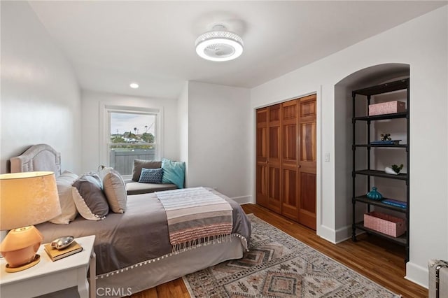 bedroom featuring wood finished floors, baseboards, recessed lighting, and a closet