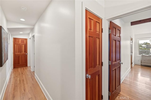 hallway featuring light wood-type flooring, baseboards, and recessed lighting