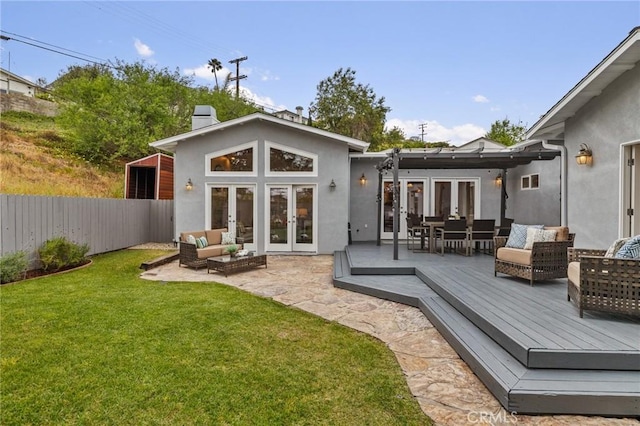 rear view of house featuring french doors, an outdoor living space, a deck, stucco siding, and a chimney
