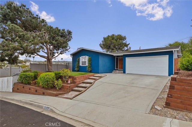 ranch-style home with stucco siding, an attached garage, concrete driveway, and fence