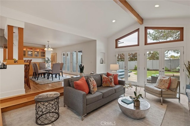 living room featuring french doors, beam ceiling, plenty of natural light, a chandelier, and high vaulted ceiling