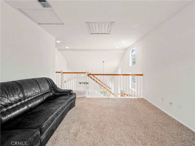 living area featuring baseboards, carpet flooring, attic access, and visible vents