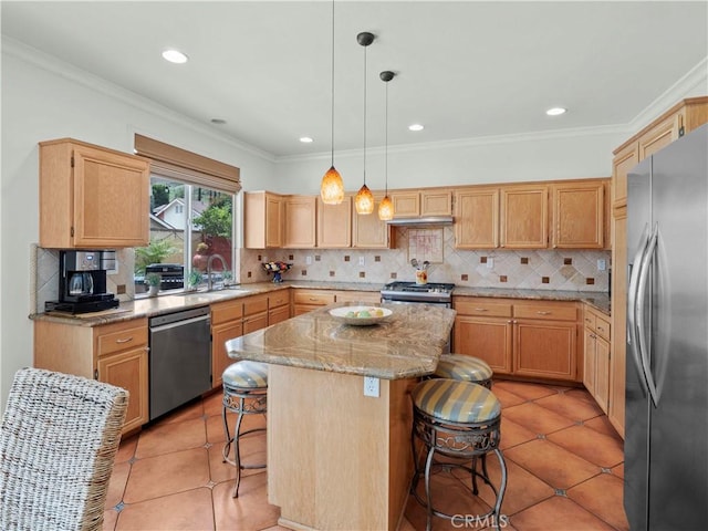 kitchen featuring a kitchen island, a kitchen bar, appliances with stainless steel finishes, tasteful backsplash, and a sink