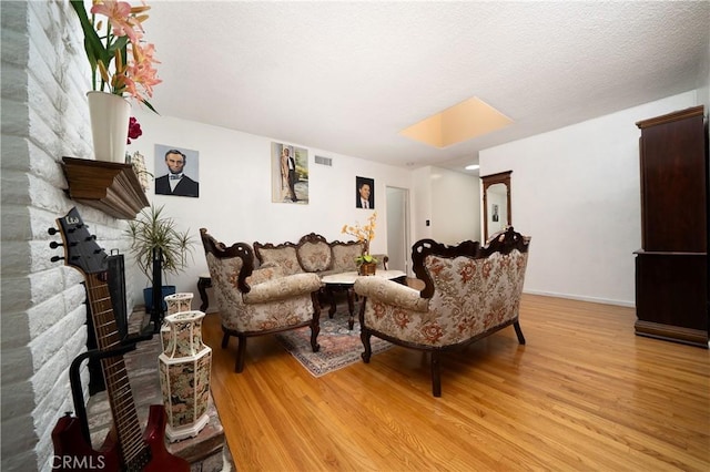 living area featuring baseboards, light wood-type flooring, and visible vents