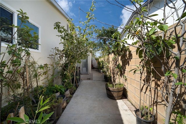 view of property exterior with fence, stucco siding, and a patio area