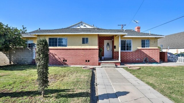 13241 Fairview St, Garden Grove, CA 92843 - view of front facade with fence, stucco siding, a front lawn, and brick siding