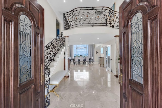 foyer featuring stairs, recessed lighting, and marble finish floor