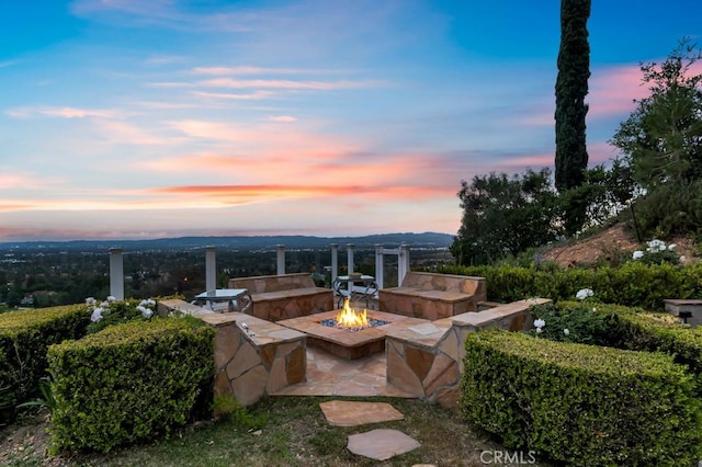 patio terrace at dusk featuring a fire pit