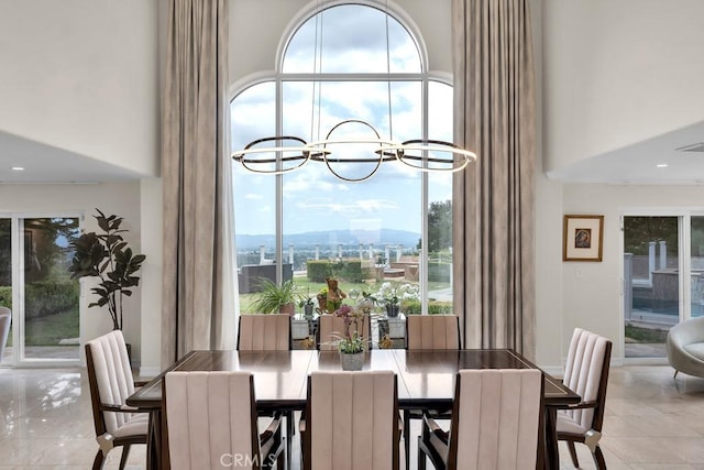 tiled dining space featuring a high ceiling and a notable chandelier