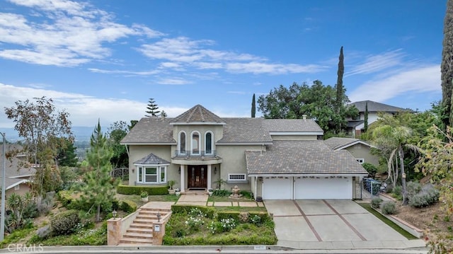 view of front of property featuring stucco siding, an attached garage, and driveway