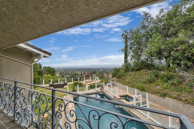 balcony featuring a pool with connected hot tub