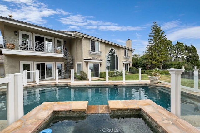 view of swimming pool featuring a pool with connected hot tub and stairway