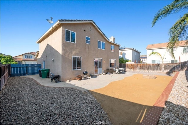 back of property featuring a fenced backyard, a patio, and stucco siding