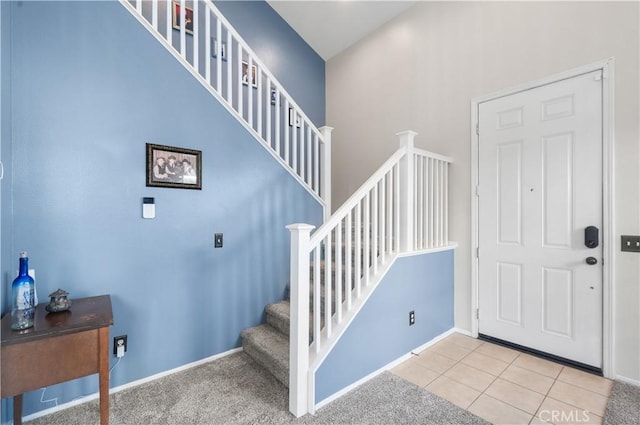 entrance foyer with baseboards, tile patterned floors, and stairs