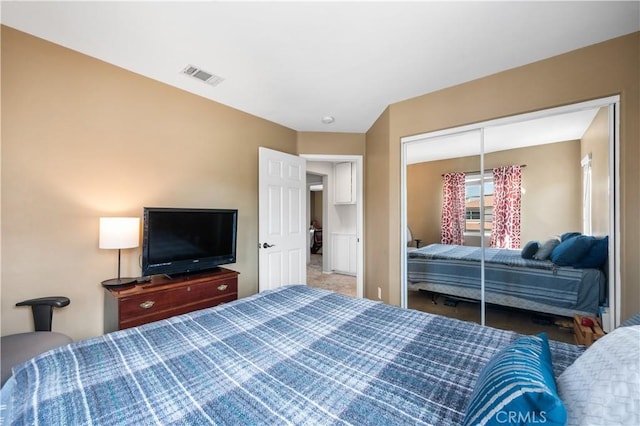 carpeted bedroom with a closet and visible vents