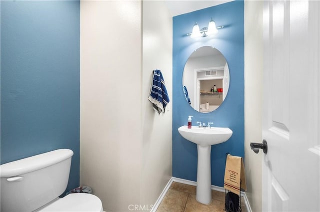 bathroom featuring toilet, a sink, and tile patterned flooring