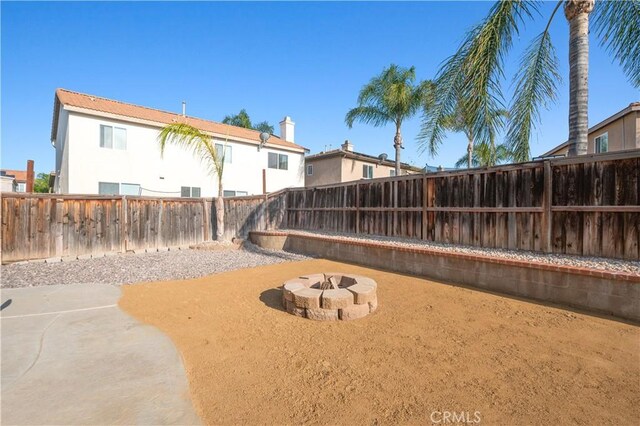 view of yard with a fenced backyard and a fire pit