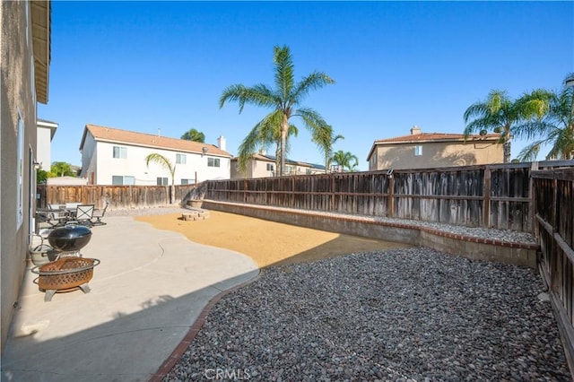 view of yard featuring a fenced backyard, a patio area, and an outdoor fire pit