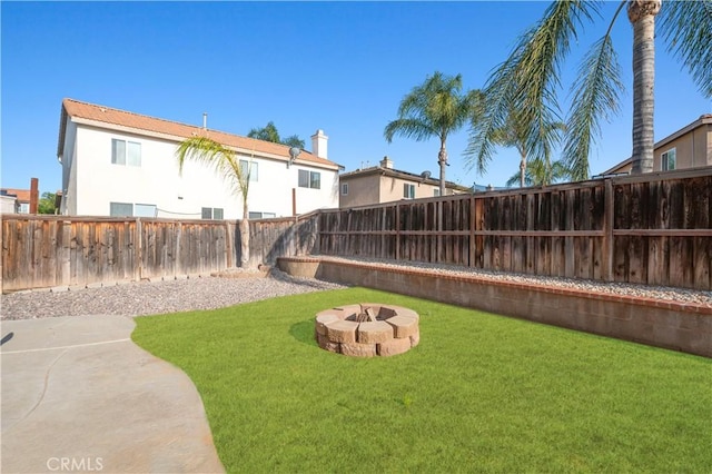 view of yard featuring a patio, a fire pit, and a fenced backyard