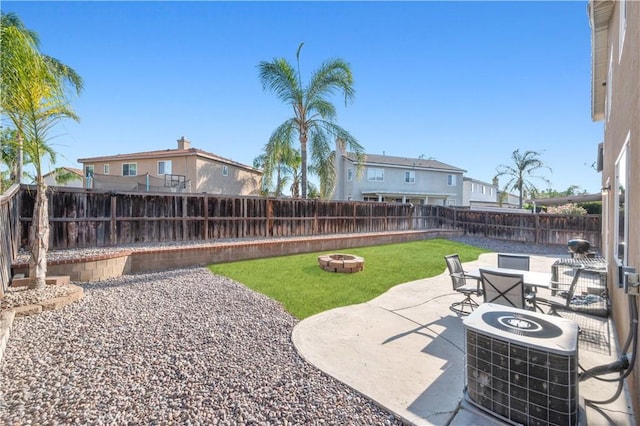 view of yard with a fenced backyard, a patio, cooling unit, and an outdoor fire pit