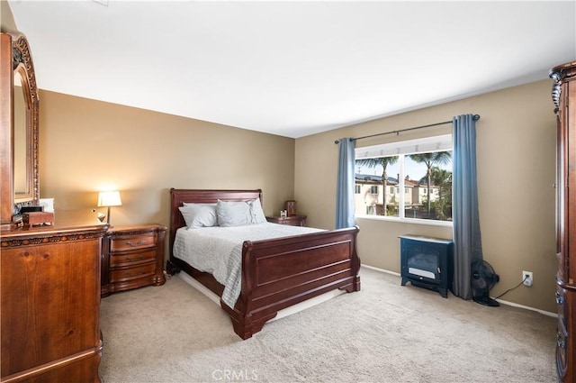 bedroom with baseboards and light colored carpet